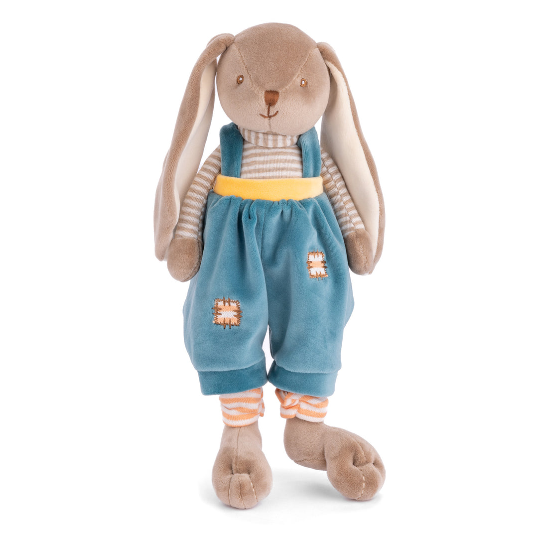 Stuffed toy rabbit wearing blue overalls and a yellow belt on a white background