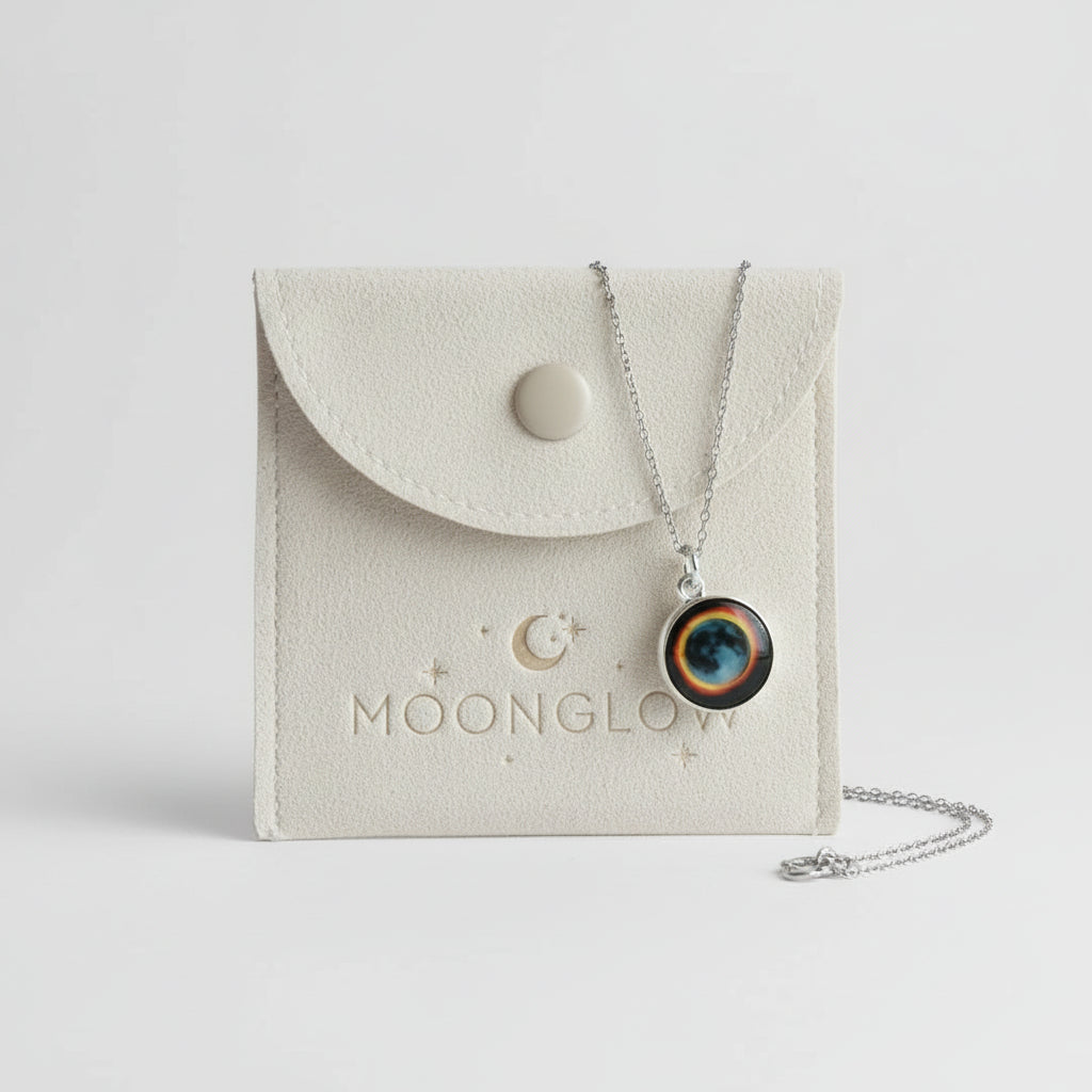 Necklace with a round pendant on a Moonglow branded pouch.