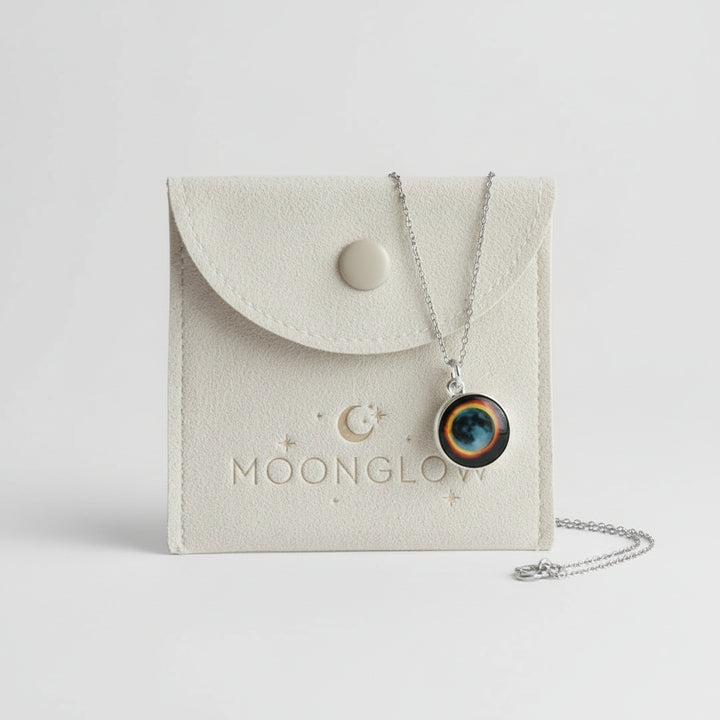 Necklace with a round pendant on a Moonglow branded pouch.