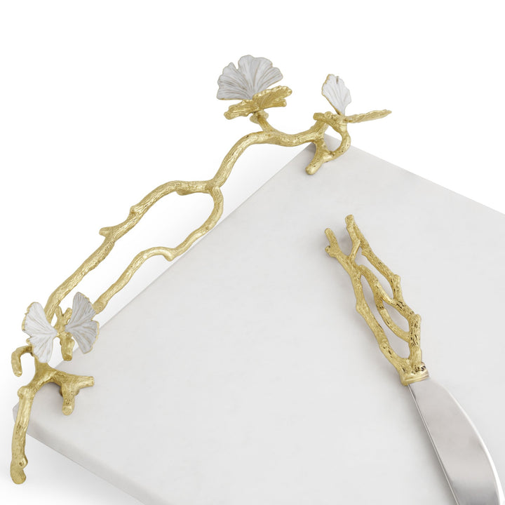 Close-up of Michael Aram Butterfly Ginkgo Gold Cheese Board showing handcrafted natural brass branches, white enamel butterflies and coordinating spreader