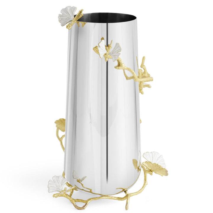 Angled view of a Michael Aram large cylindrical metal vase with a reflective silver-tone body, sculpted gold ginkgo branches and white ginkgo leaf accents that resemble butterflies.