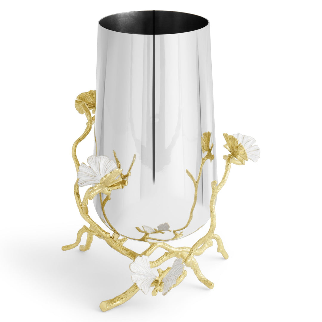 A Michael Aram modern cylindrical metal medium vase, 9.75 inches high, with a reflective silver-tone body, decorated with sculpted gold ginkgo branches and white ginkgo leaf accents that resemble butterflies.