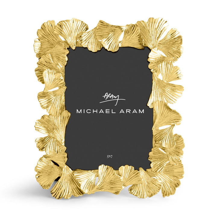 Michael Aram 5x7' gold picture frame with a textured, ginkgo leaf scalloped border, shown with a black insert displaying the Michael Aram logo, displayed verticallly