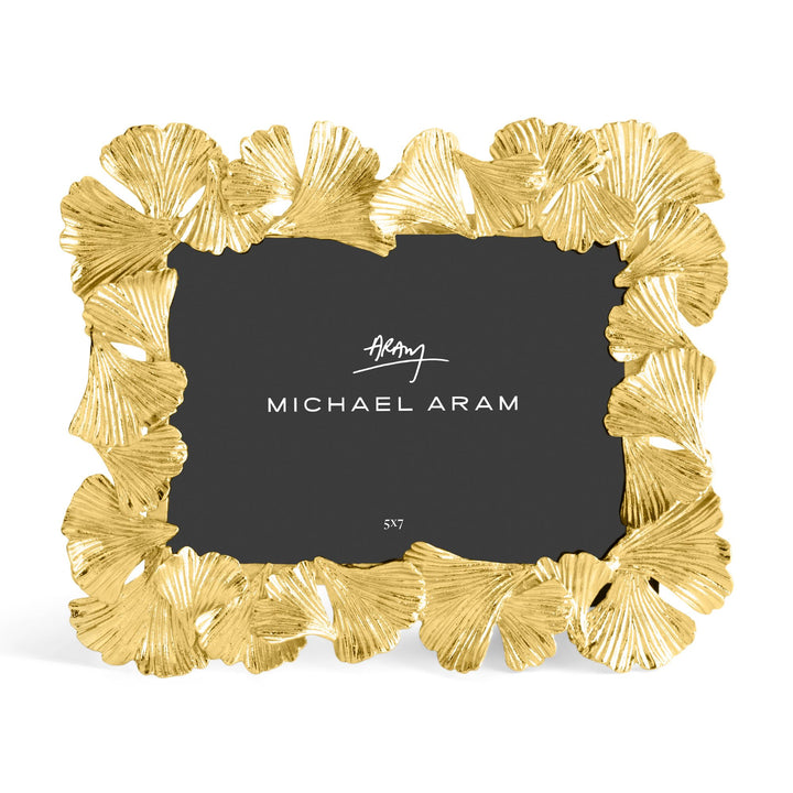 Michael Aram 5x7" gold picture frame with a textured, ginkgo leaf scalloped border, shown with a black insert displaying the Michael Aram logo and sitting horizontally 
