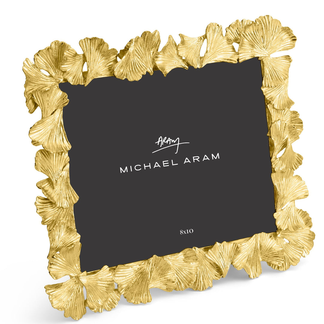 Michael Aram 8x10" gold picture frame with a textured, ginkgo leaf scalloped border, shown with a black insert displaying the Michael Aram logo, displayed horizontally