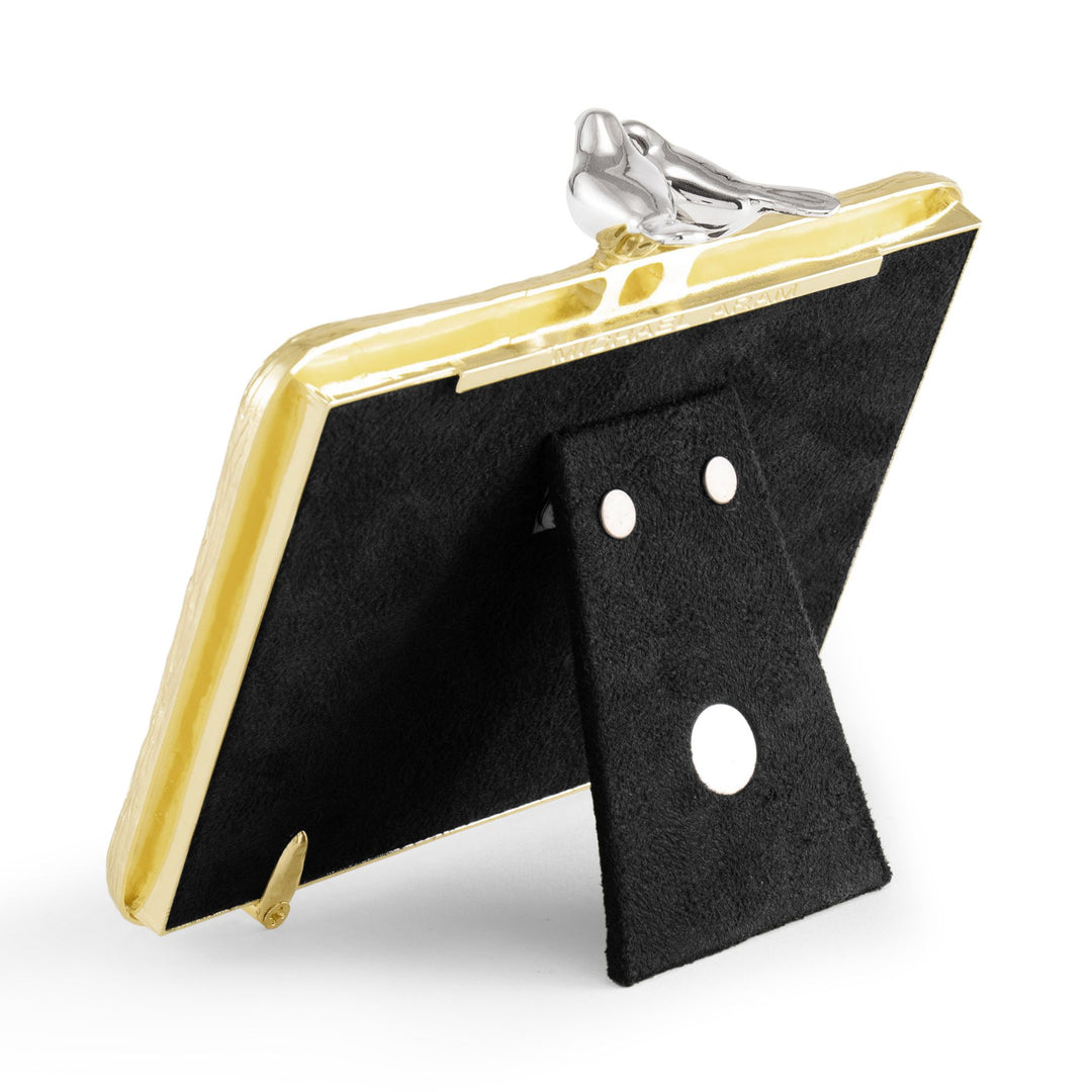 ALT: Back angled view of Michael Aram Lovebirds 4x6 picture frame showing the gold-tone frame edge, sculpted silver-tone lovebirds and black easel stand