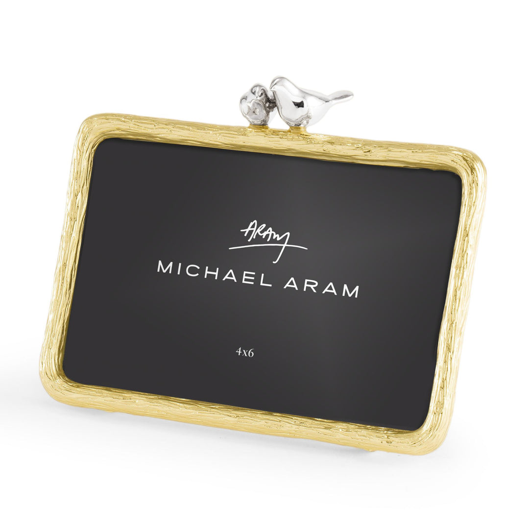 Left-angle view of Michael Aram Lovebirds 4x6 picture frame showing the textured gold-tone frame and dimensional silver-tone lovebirds perched together at the top