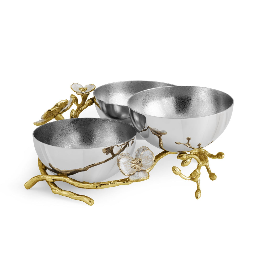 Side view of Michael Aram Orchid Triple Low Bowl showing three silver-tone bowls arranged among dimensional goldtone orchid branches with white enamel flowers and buds