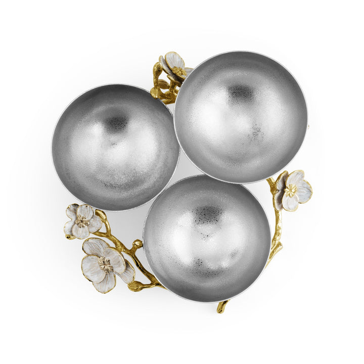 Top view of Michael Aram Orchid Triple Low Bowl showing three textured silver-tone bowl interiors surrounded by dimensional goldtone orchid branches and white enamel flowers