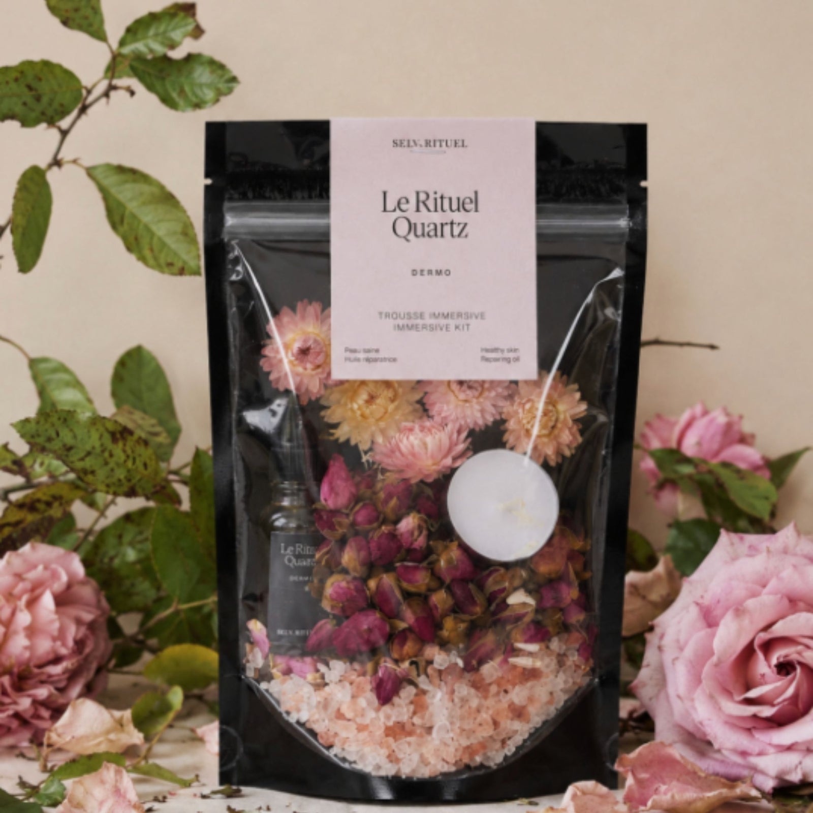 Selv Rituel Luxury Botanical Bath kit shows dried flowers, pink bath salts, a small bottle of quartz rose bath and body oil, and a white votive candle