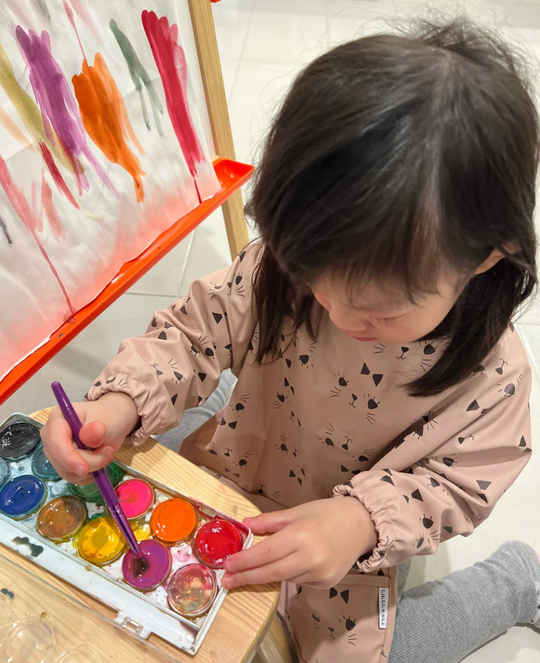 Child wearing a Oeko-tex approved, 100% recycled polyester smock for crafting, playing or messy eaters