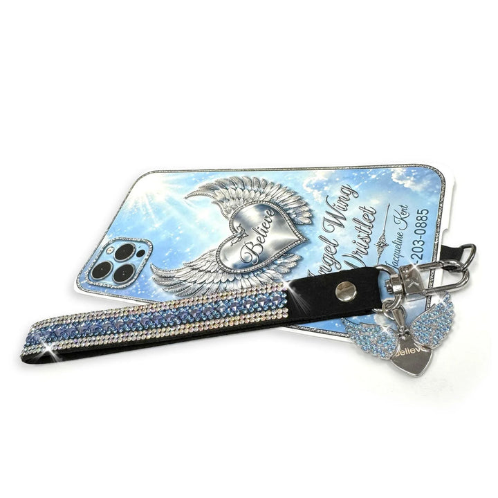 Jacqueline Kent rhinestone phone wrist lanyard in  bluw and silver with an angel wing charm hiding a heart that says believe