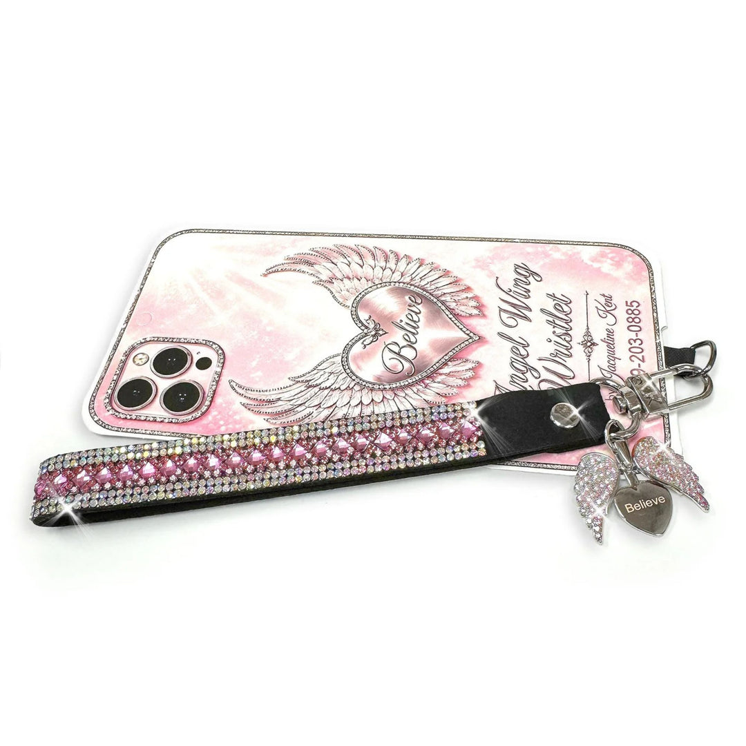 Jacqueline Kent rhinestone phone wrist lanyard in  pink and silver with an angel wing charm hiding a heart that says believe