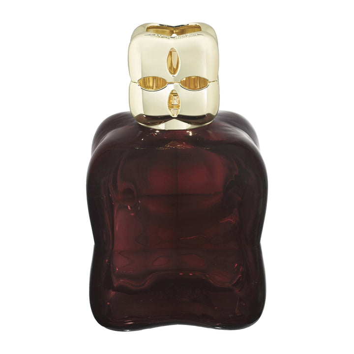 Lampe Berger Cosy Plum home fragrance lamp in deep plum glass with softly undulating sides with a gold-coloured top with oval cut-outs.
