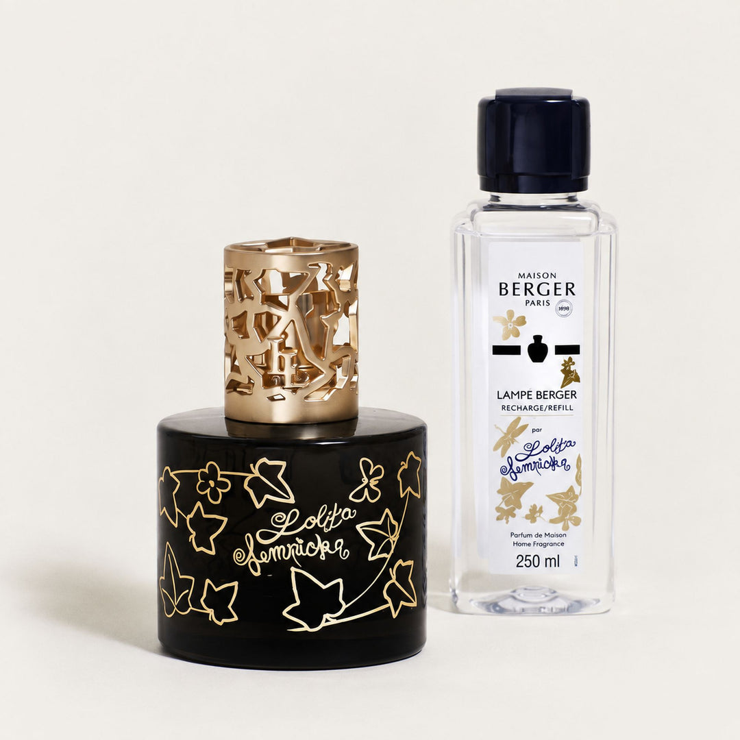 Lampe Berger Lolita Lempicka home fragrance lamp in black glass with gold ivy-leaf decoration and an ornate gold-coloured metal diffuser top, beside a 250ml Lolita Lempicka fragrance refill.

