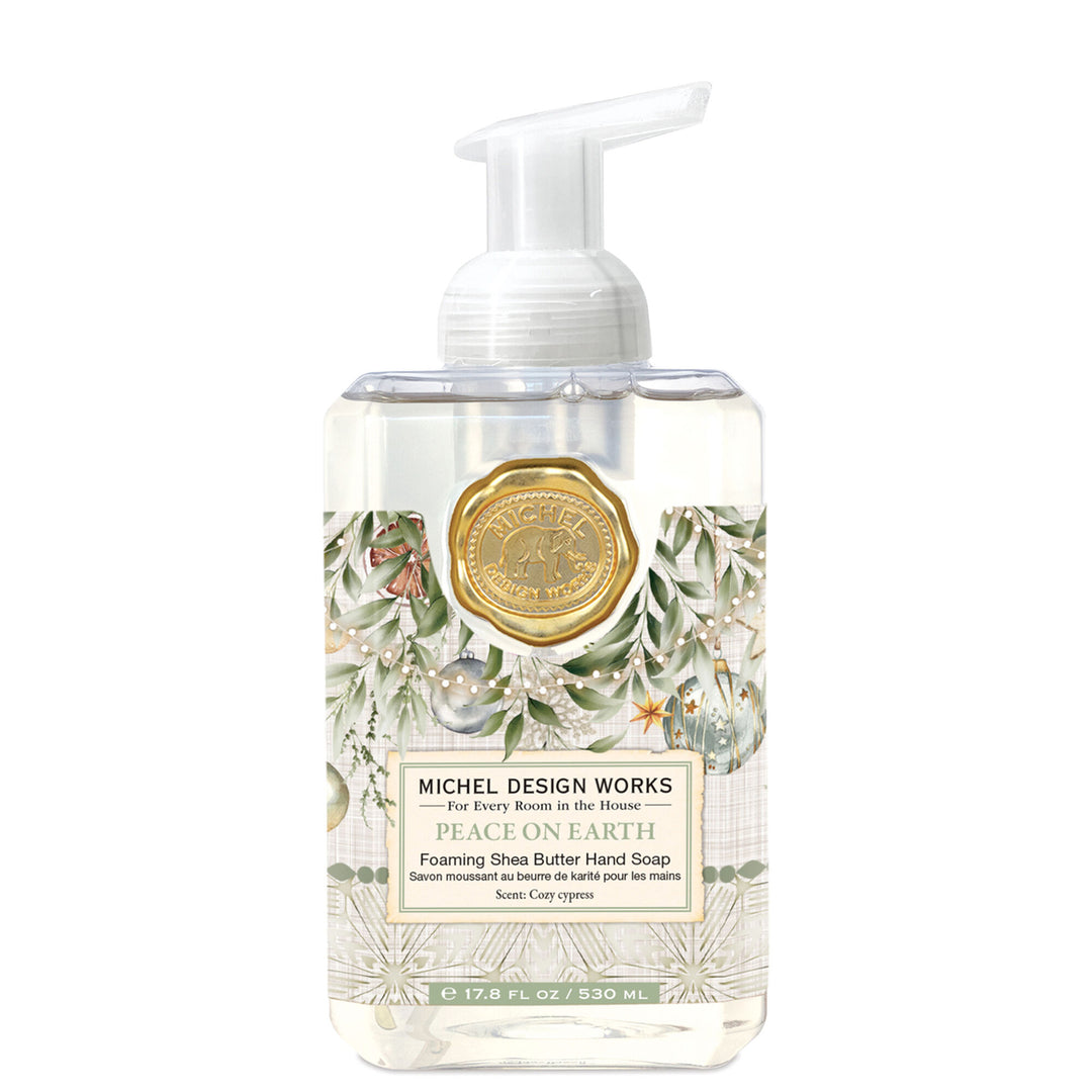 Michel Design Works Peace on Earth 530 ml foaming hand soap with white pump, green foliage and Christmas ornaments.