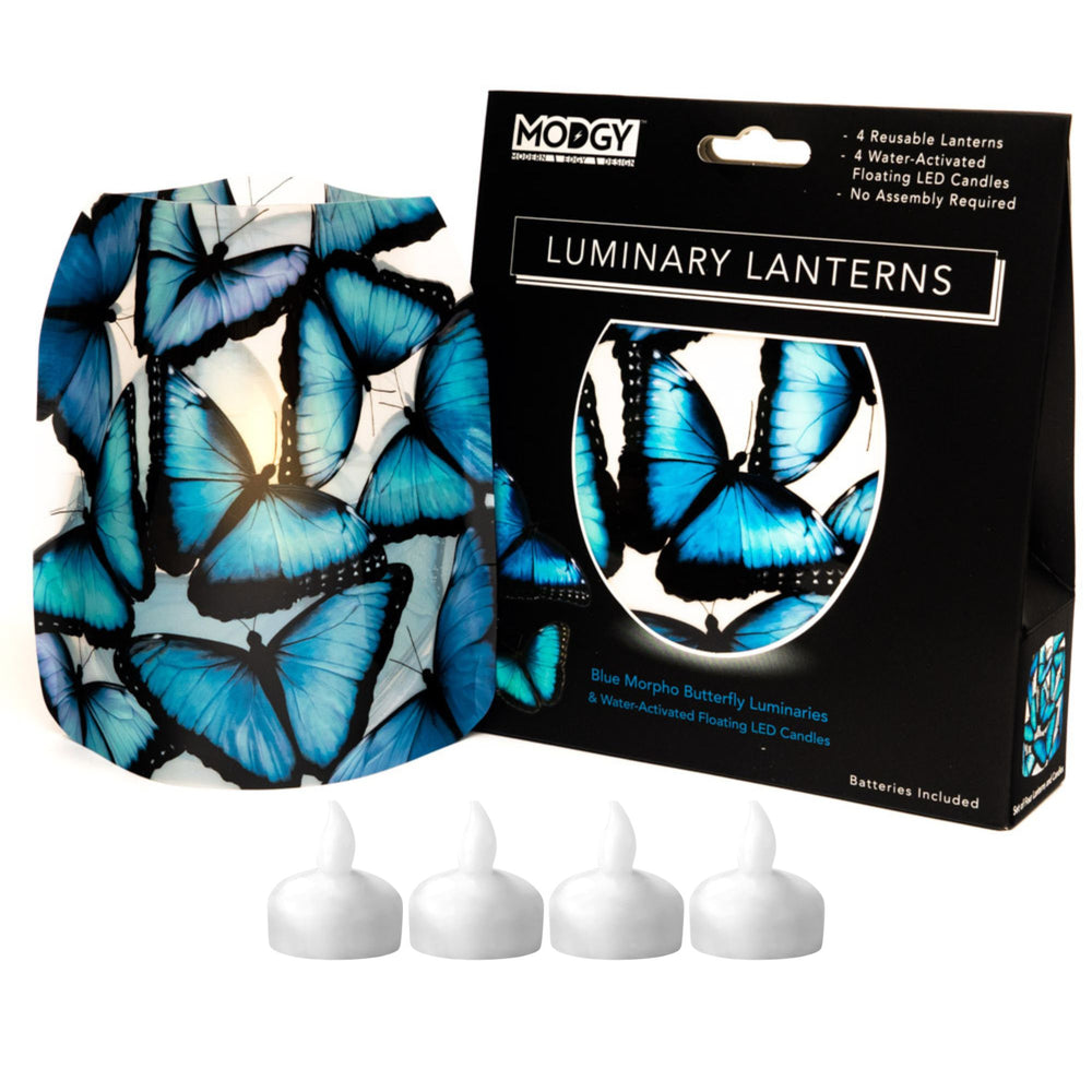 Modgy Luminary Lanterns featuring stained-glass-like blue morpho butterfly patterned reusable floating LED candles, shown with its black gift box packaging and four white battery-operated candle inserts.