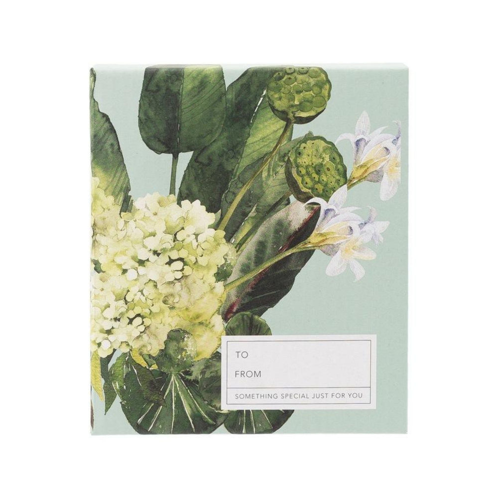 A rectangular greeting card style box with a botanical illustration of green leaves, white flowers, and green seed pods on a pale mint background. A white label on the lower right reads 'TO FROM SOMETHING SPECIAL JUST FOR YOU'. contains a mom sentiment plaque with easel